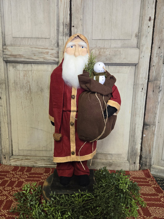 Large Primitive Santa Wearing Red Coat Holding a Bag with Snowman