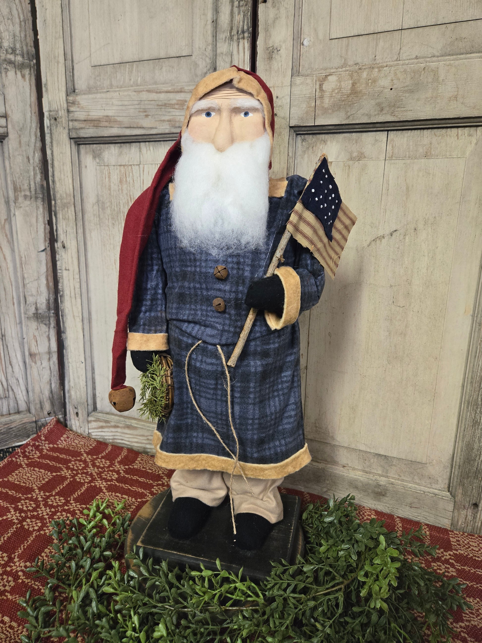 Large Primitive Santa Wearing Blue Coat with Flag and Wreath